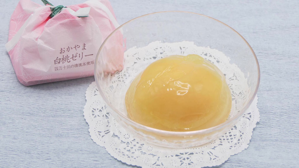 透明なお皿に入れられた御菓子処 清風庵の商品「おかやま白桃ゼリー」とそのパッケージ